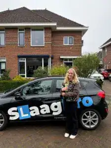Gecertificeerde rijschool Slaagpro met auto en jonge cursist voor succesvolle rijopleiding.